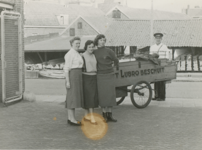 861069 Afbeelding van drie kantoormedewerksters en broodbezorger Jan Ekkerman van de Lubro, bij de ingang van de nieuwe ...